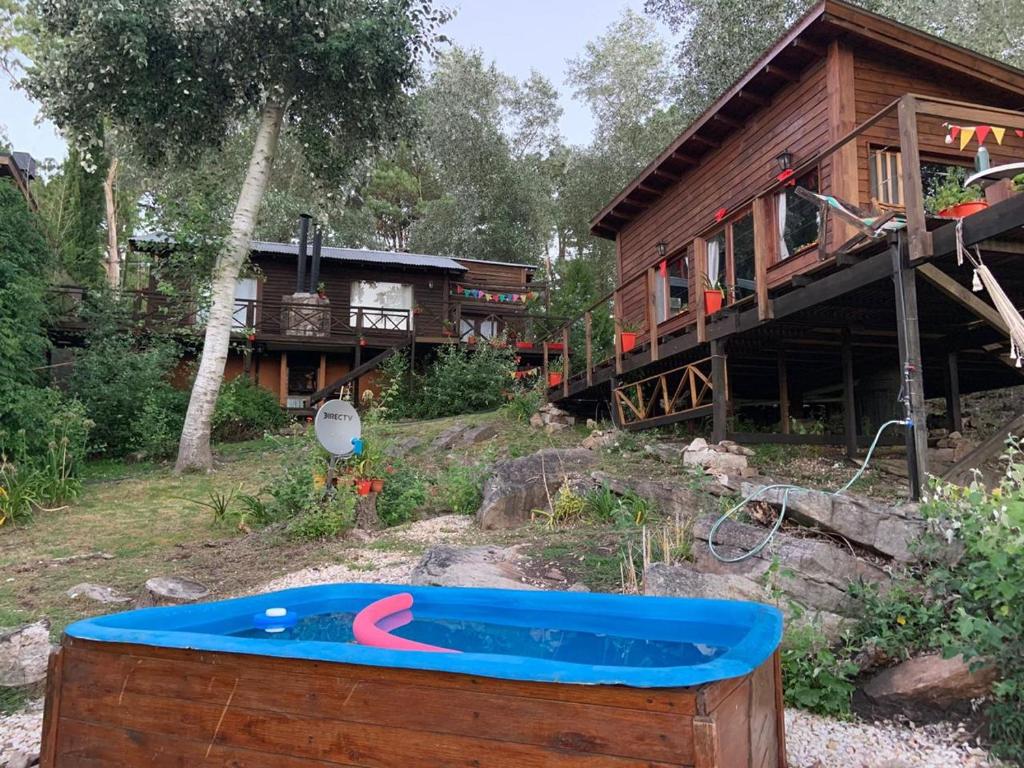 una casa con bañera de hidromasaje frente a una casa en Cabaña Sierra en Sierra de los Padres
