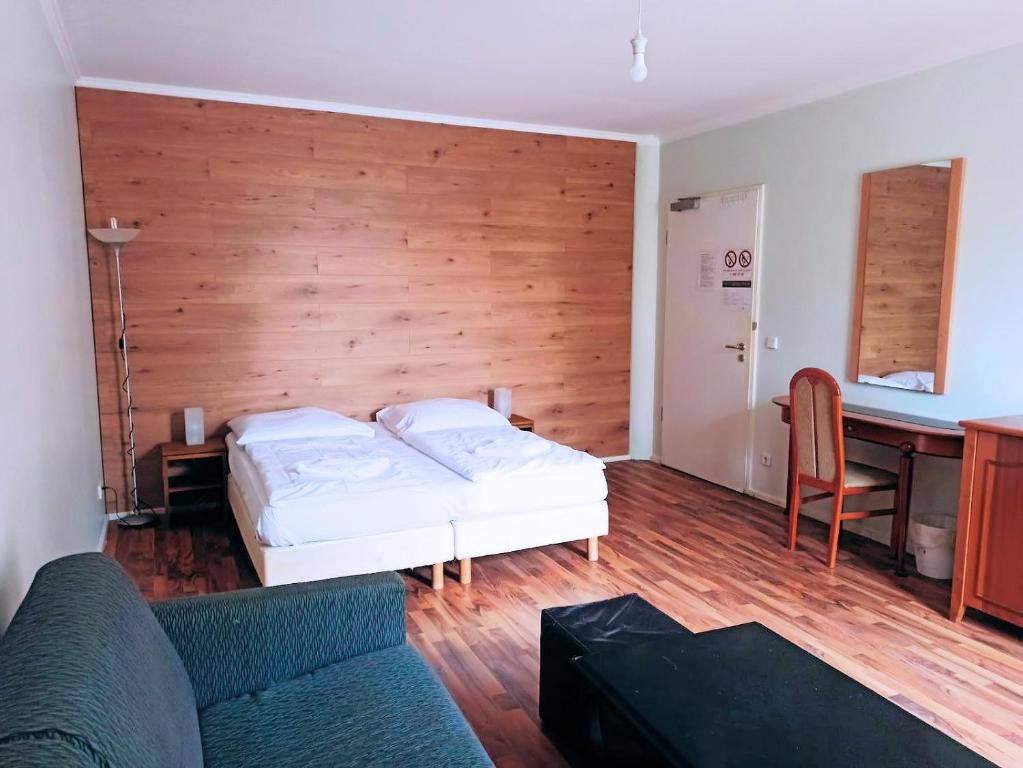 - une chambre avec un lit, un bureau et un canapé dans l'établissement Puschkin Rooms, à Berlin