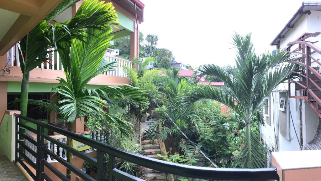 a balcony of a building with palm trees at Reynaldo's Upstairs in Puerto Galera