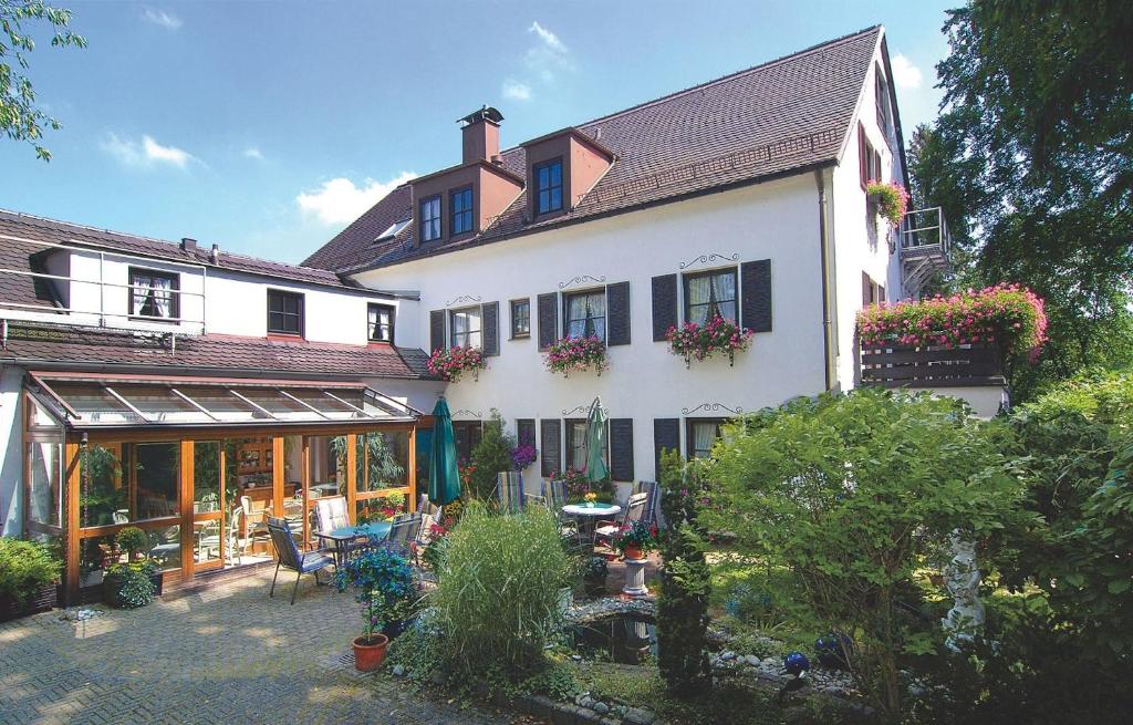 Una gran casa blanca con un patio enfrente. en Hotel Neuner, en Múnich