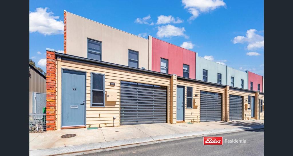 a building with garage doors on the side of a street at Old Port Townhouse Central to Everything in Echuca