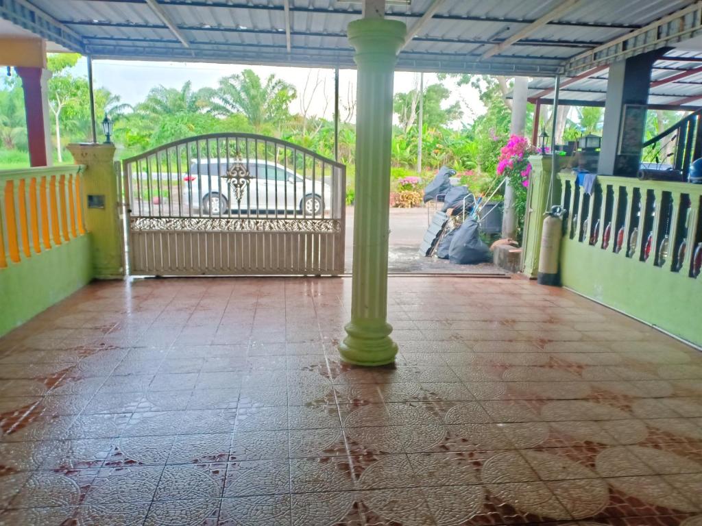 a porch with a pillar and a gate with a car parked at D'Hiquapis Homestay in Seri Manjung