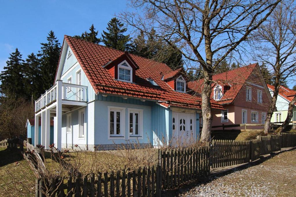 a white and blue house with a red roof at Cottages in fir park, fir in Tanne