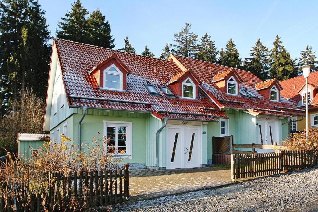 una casa con techo verde y rojo en Cottages in fir park, fir en Tanne