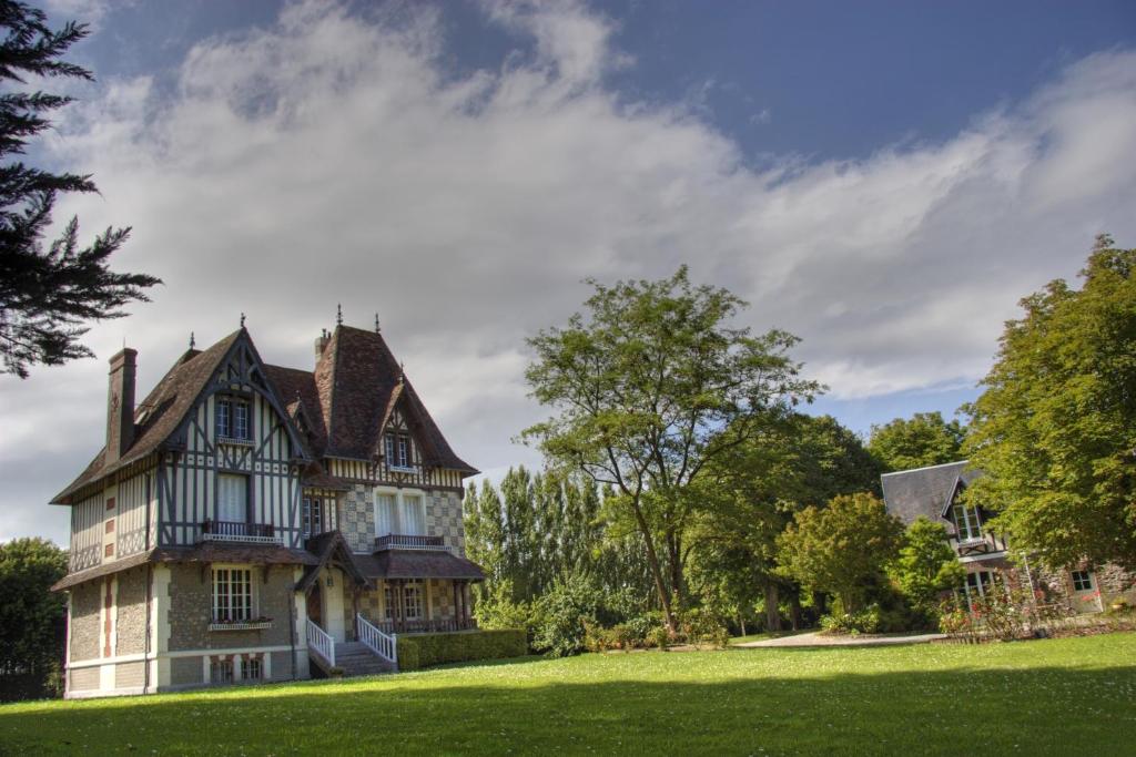 stary dom na zielonym trawniku w obiekcie Le Clos des Pommiers w mieście Blainville-sur-Mer