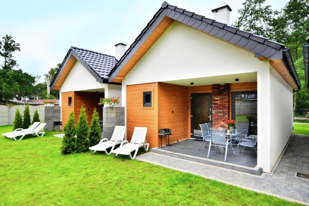 a cottage with a patio and lawn at Family holiday homes, Jaroslawiec in Jarosławiec