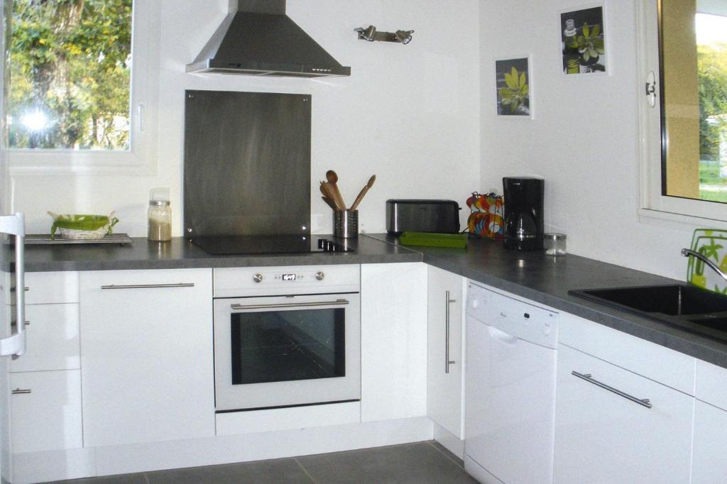 a kitchen with white cabinets and a stove top oven at holiday home, Grayan-et-l&#39;Hôpital in Grayan-et-lʼHôpital