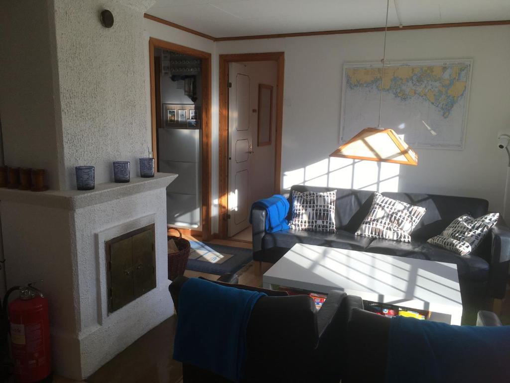 uma sala de estar com um sofá e uma lareira em Idyllic bungalow close to sea and forest em Ronneby