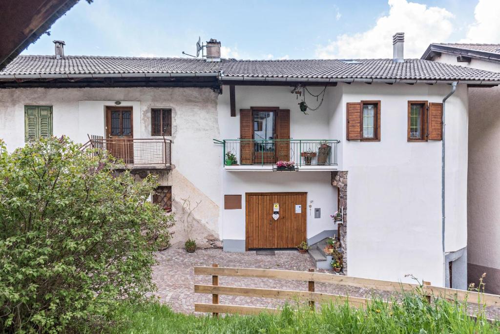 Biały dom z drewnianymi drzwiami i ogrodzeniem w obiekcie Casa Sicina Albina w mieście Sicina