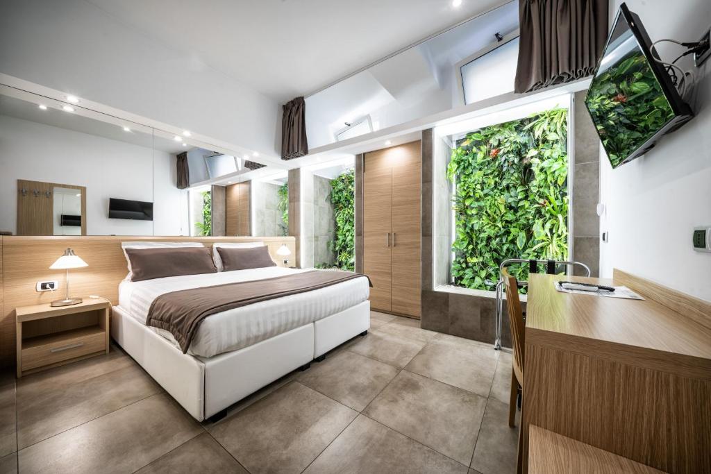 a bedroom with a bed and a desk and windows at Hotel Paolo II in Rome