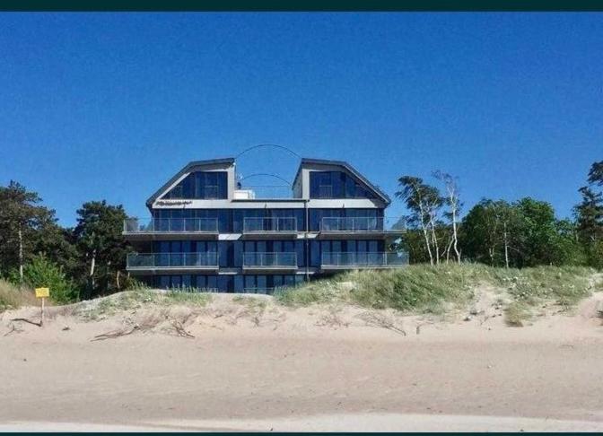 un grand bâtiment au sommet d'une plage dans l'établissement Apartament na wydmie - Darłowo, à Darłowo