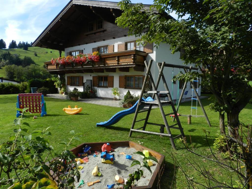 einen Hof mit einem Sandkasten, einem Spielset und einem Haus in der Unterkunft Gästehaus Glaagut - Familie Hain in Hochfilzen