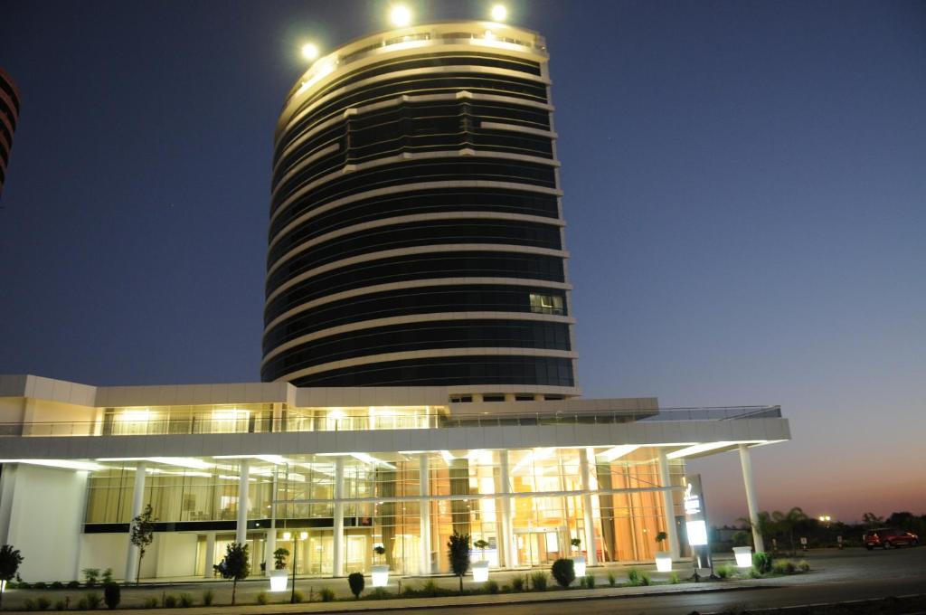 un gran edificio con una torre alta por la noche en Anemon Grand Adana Otel, en Adana