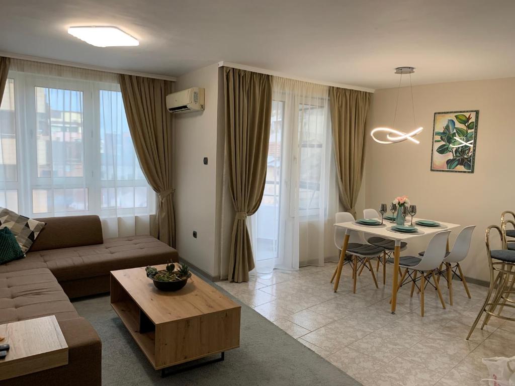 uma sala de estar com um sofá e uma mesa em Unbeatable Location: New & Comfy Apartment em Varna City