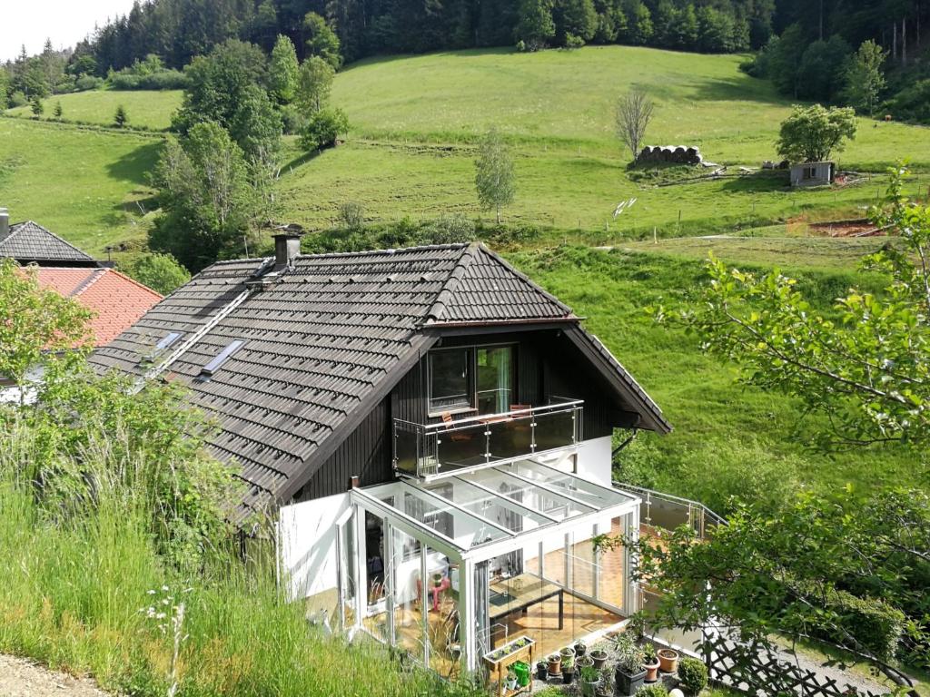 ein kleines Haus mit schwarzem Dach auf einem Hügel in der Unterkunft Ferienwohnung Glashütte in Sankt Märgen