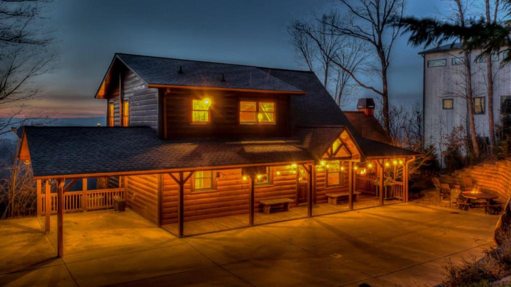 una gran cabaña de madera con luces encendidas por la noche en Valhalla View, en Blue Ridge