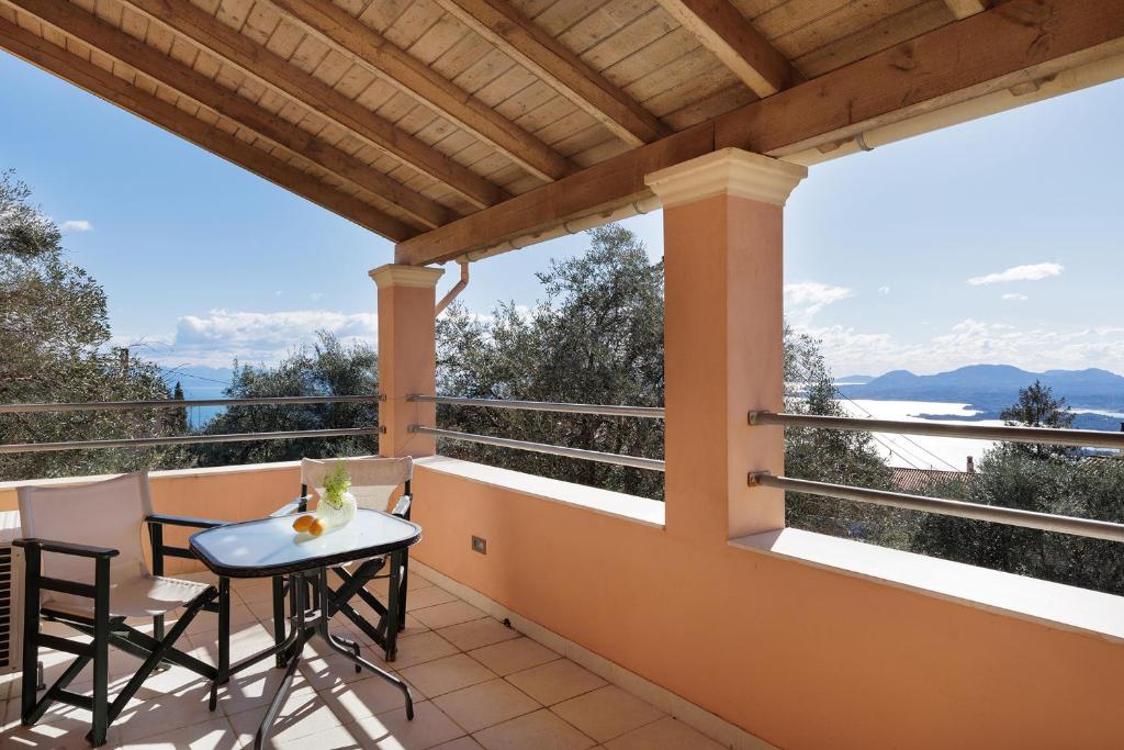 a balcony of a house with a table and chairs at Villa Elia, Spartylas Corfu in Spartýlas