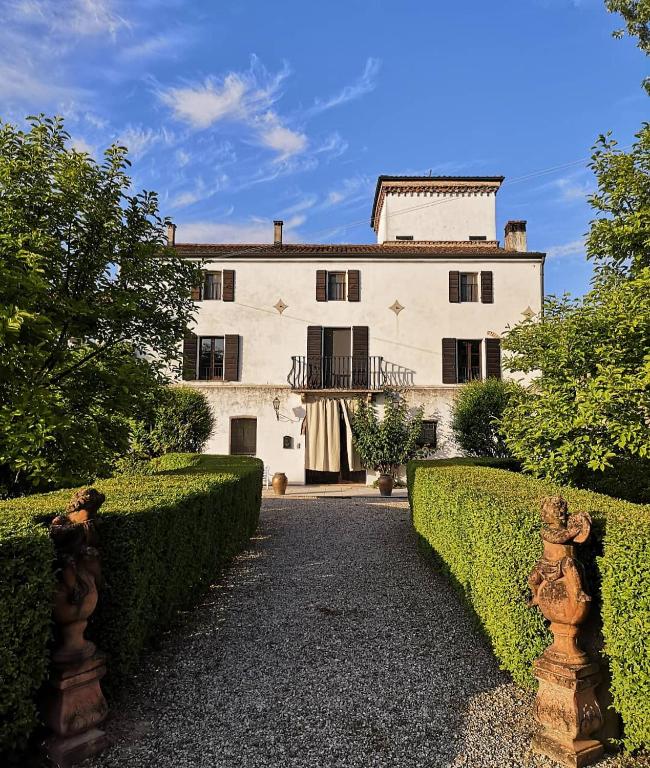 a large white house with hedges in front of it at Agriturismo Corte Spino in Nogarole Rocca