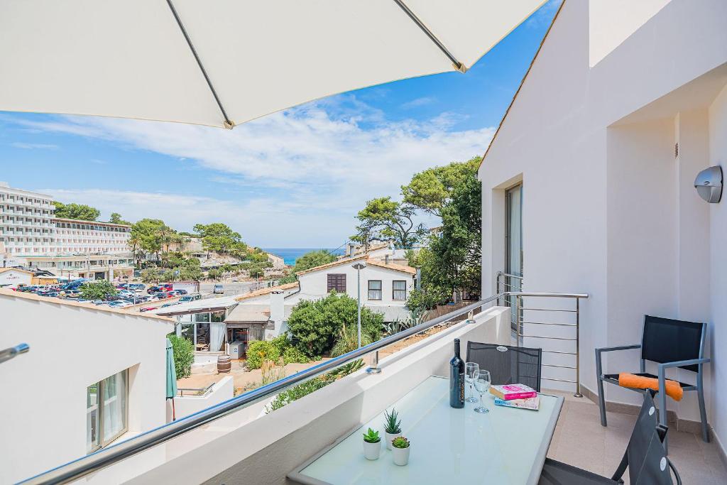 a balcony with a table and a view of the city at MOLINS 2 in Cala de Sant Vicenc