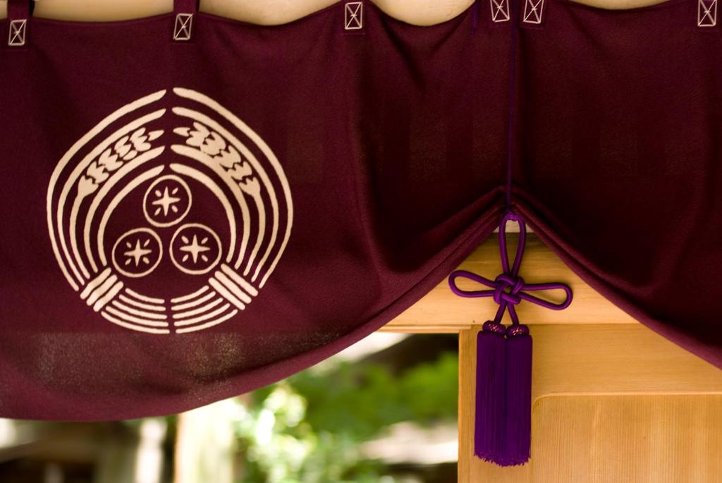 a close up of a red curtain with a bow at Toushinan Komeya in Ito