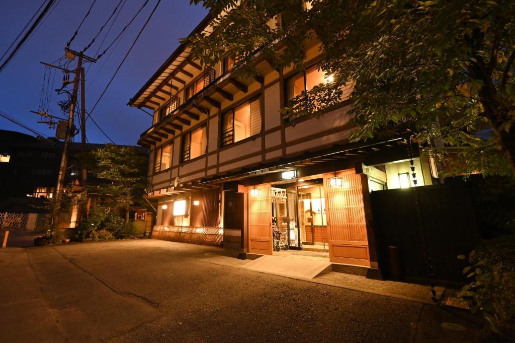 um edifício com as suas portas iluminadas à noite em Ryokan Tamura em Kusatsu