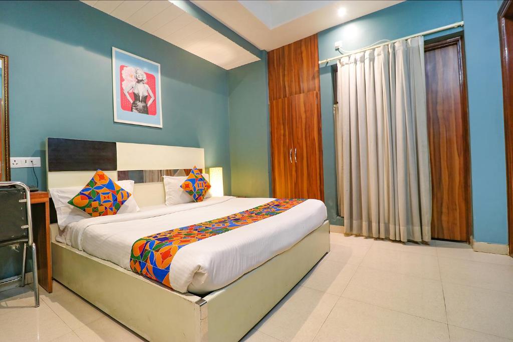 a bedroom with a large bed with blue walls at FabHotel Church House Rohini in New Delhi