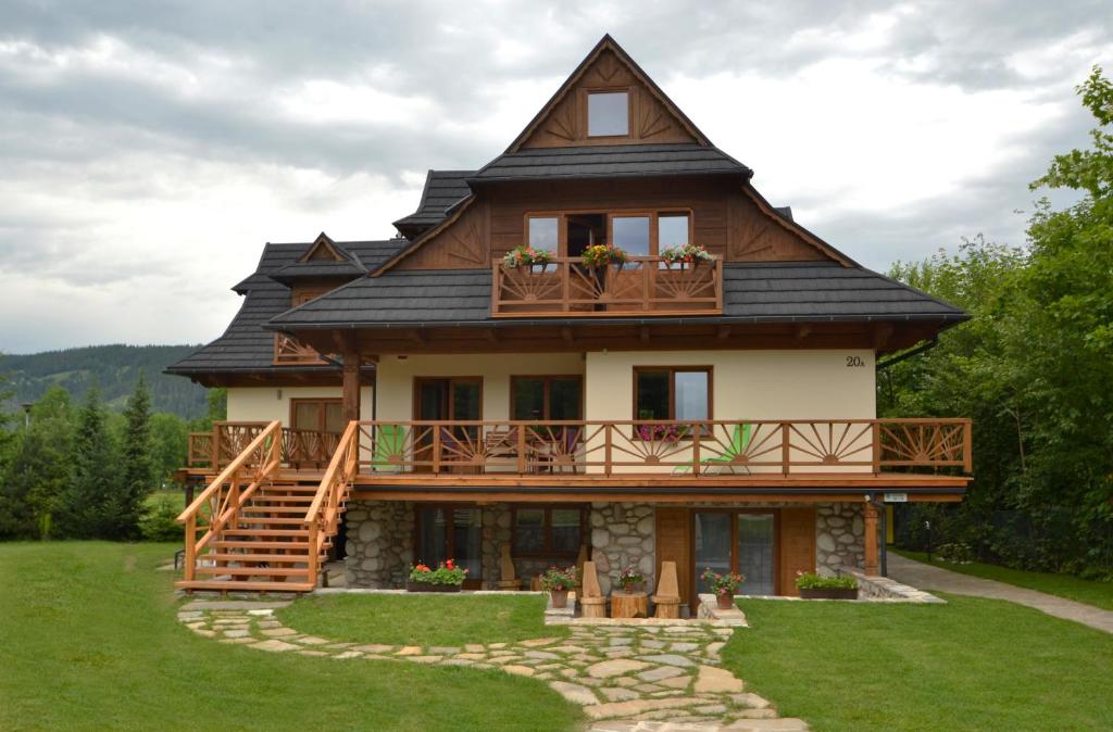 une grande maison avec un toit en gambrel dans l'établissement Willa na Równi, à Zakopane