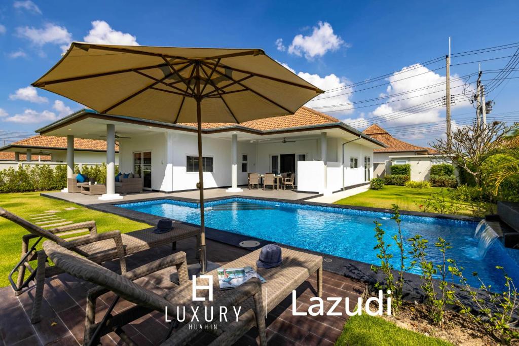 a villa with a swimming pool and an umbrella at Modern 3 Bedroom Pool Villa MS24 in Hua Hin