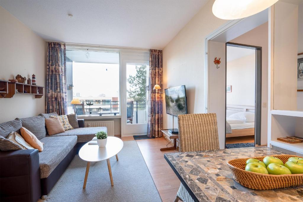 ein Wohnzimmer mit einem Sofa und einem Tisch in der Unterkunft Haus Meeresblick Wohnung 47 in Kellenhusen