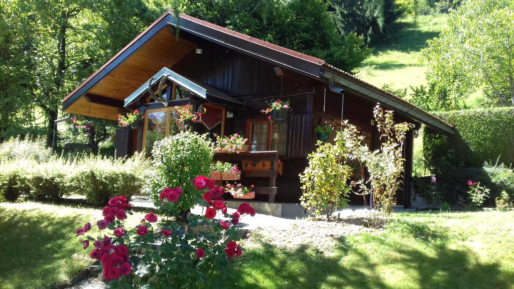 una pequeña casa con flores delante en Chalet Chez Nous, en Domancy