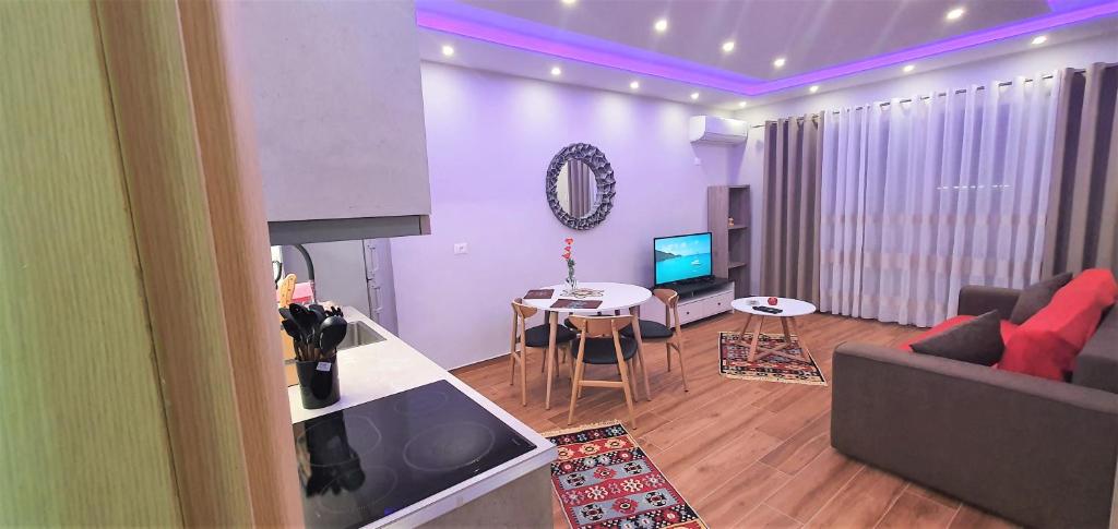 een woonkamer met een bank, een tafel en een televisie bij Eni`s Apartments in Tirana