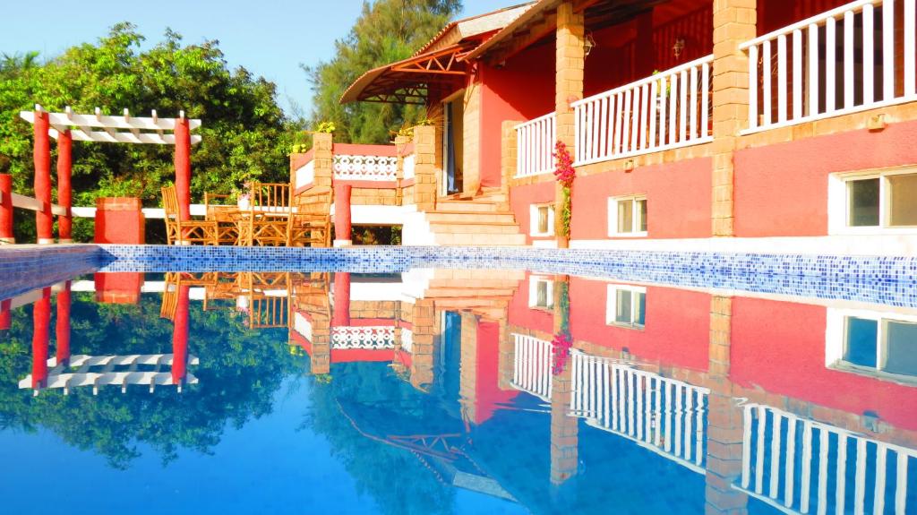 a reflection of a building and a swimming pool at Kasa MANSA in Kafountine