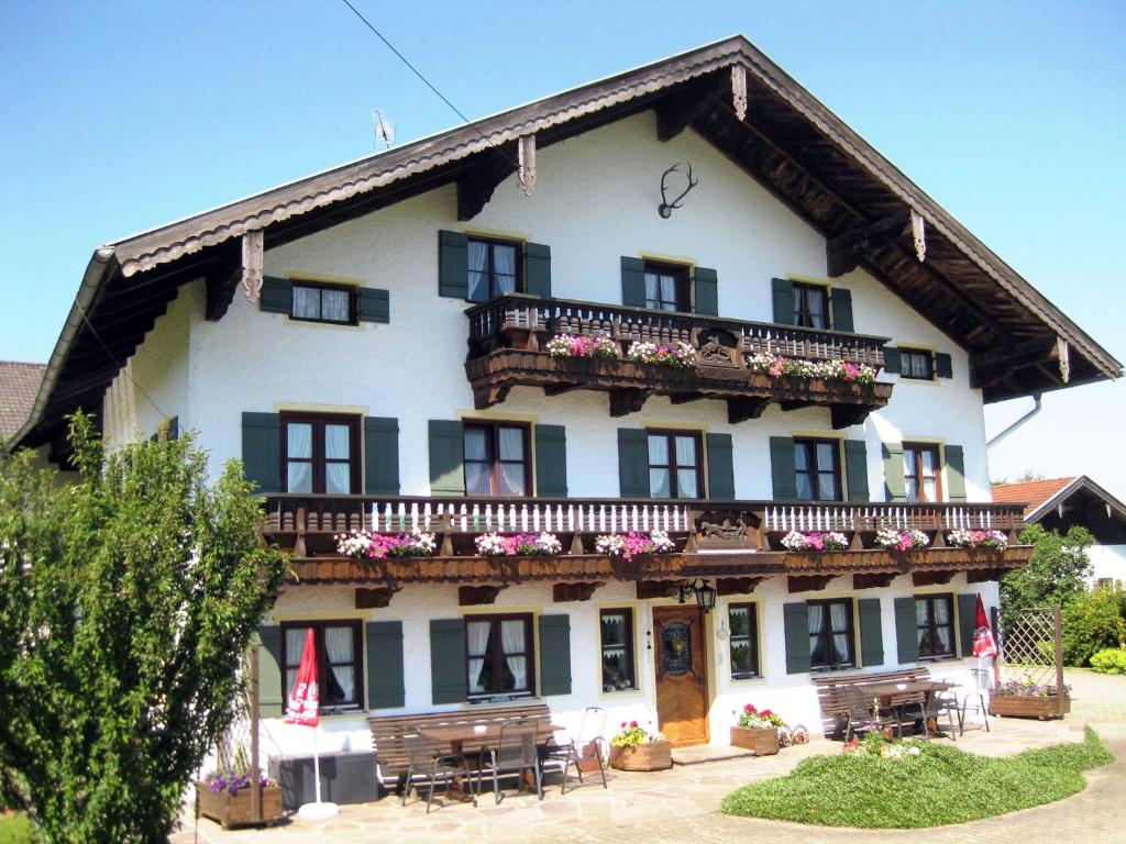 ein großes weißes Gebäude mit einem Balkon und Tischen in der Unterkunft Sträublhof in Wonneberg