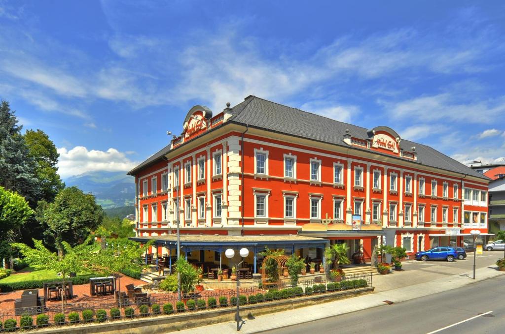 ein großes rotes Gebäude an der Straßenseite in der Unterkunft Hotel Ertl & mexican cantina salud in Spittal an der Drau