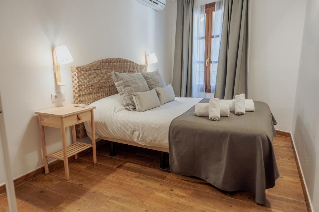 1 dormitorio con 1 cama con 2 toallas en Apartamentos Villacantal, en Alquézar