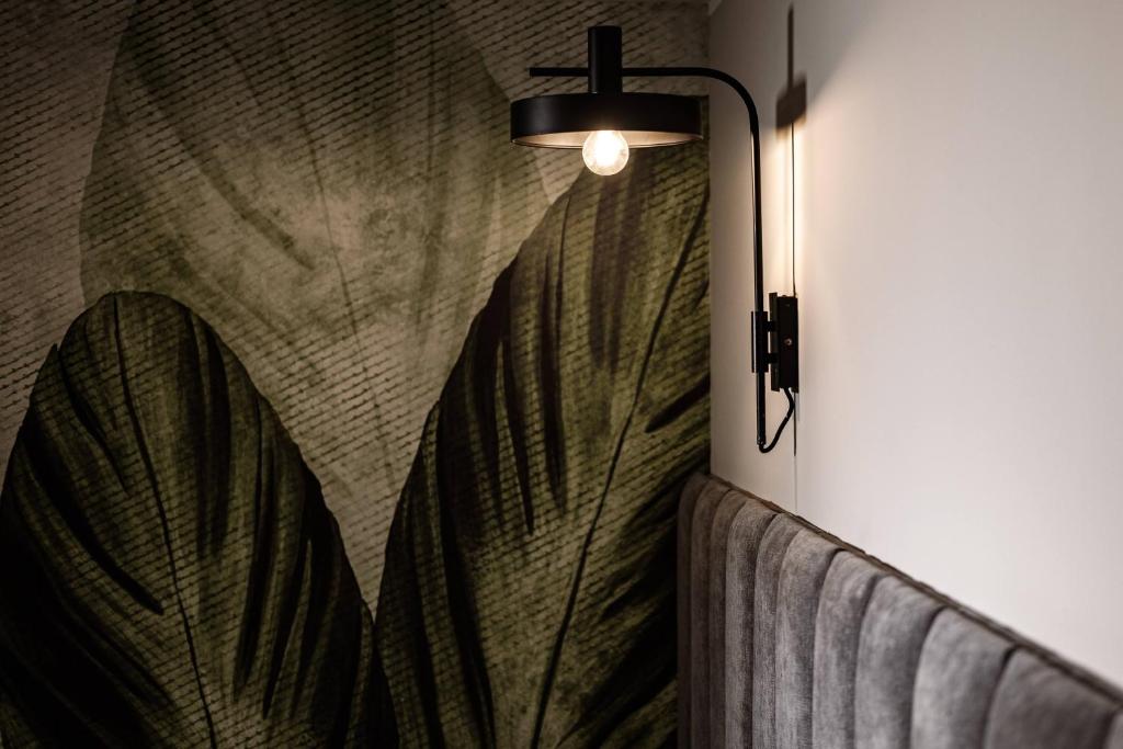 a wall mounted lamp with a leaf design on a wall at Amery House in Sliema