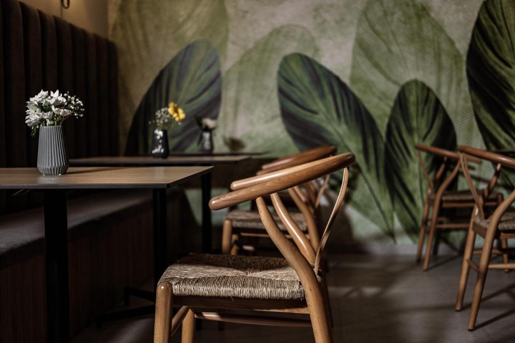 a room with chairs and tables and a mural of plants at Amery House in Sliema
