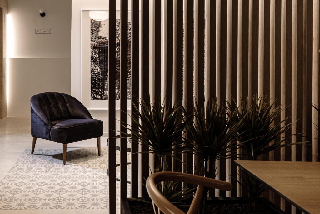 a room with a chair and a table and plant at Amery House in Sliema