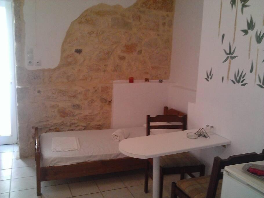 a room with a table and a bed and a table and chairs at Studio 10 minutes from the center of Heraklion. in Heraklio