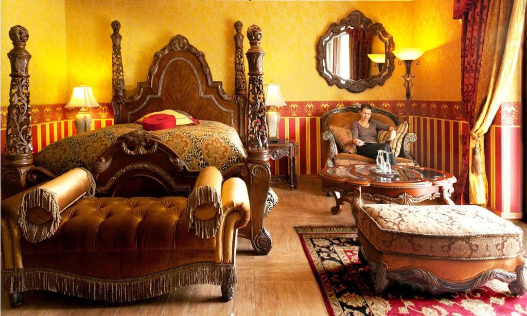 una donna seduta su una sedia in una stanza con un letto di Burg Hotel Romantik a Gotha