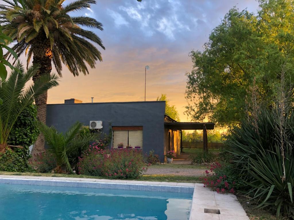 una casa con piscina frente a una casa en Cabaña La Finca en San Rafael