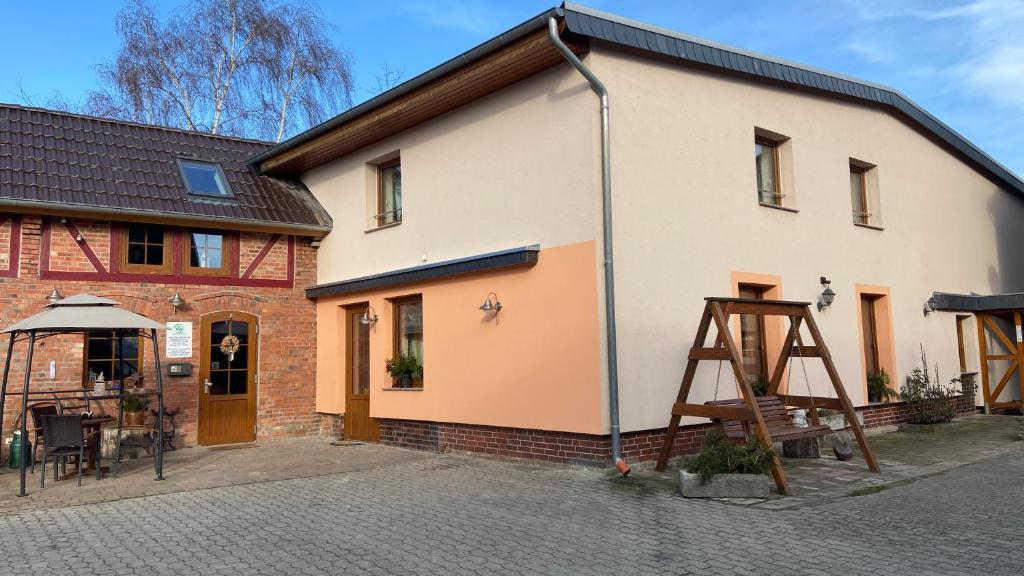 a building with a wooden ladder next to it at Pension Bauer Schulze in Groß Twülpstedt