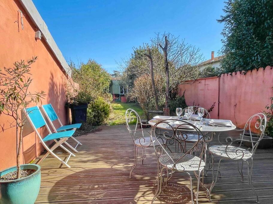 une table et des chaises assises sur une terrasse dans l'établissement ⧗ Lisle au Trésor ⧗ Loft d'architecte avec jardin, à Lisle-sur-Tarn