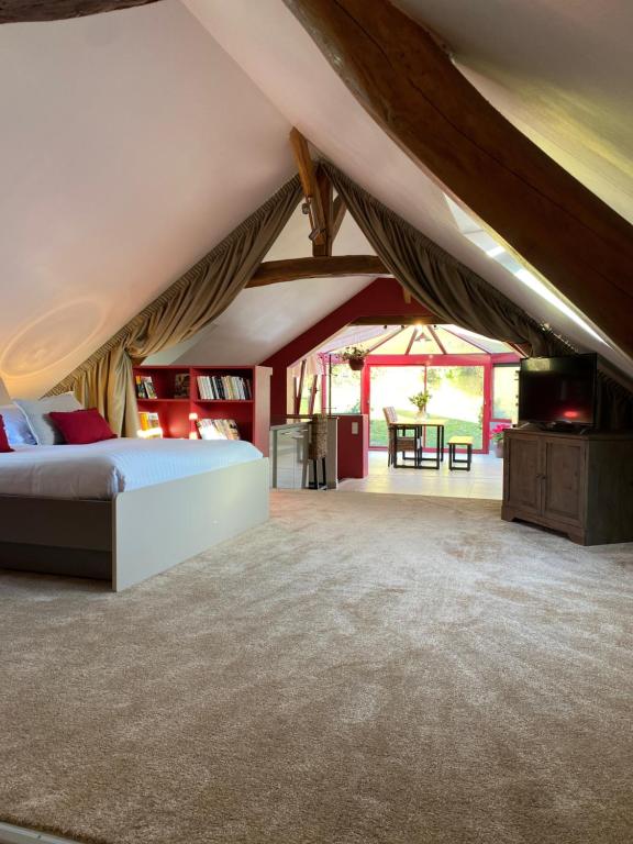 a bedroom with a bed and a tv in a tent at A l'Ombre d'Azay - Demeure d'Hôtes in Azay-le-Rideau