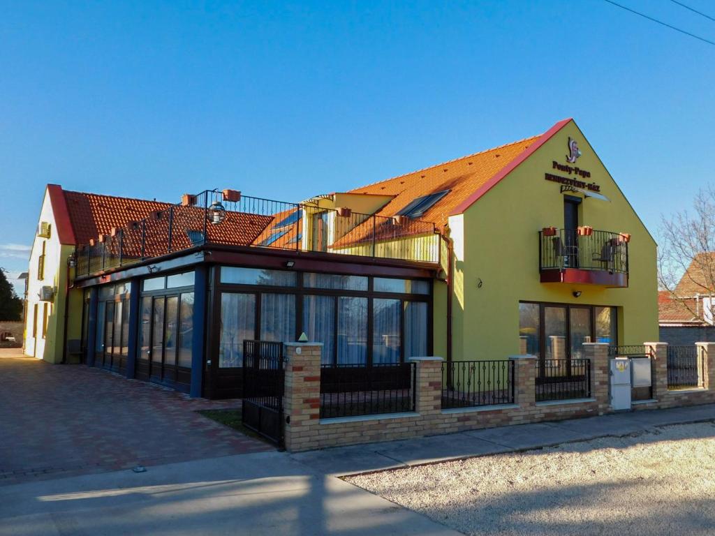 un edificio con una tienda con ventanas y techo en Ponty-Papa Rendezvényház, en Dávod
