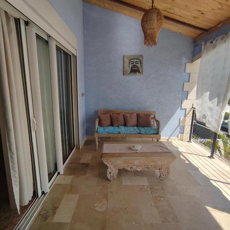 a living room with a couch and a table at Spacieux appart T3 à st gilles les bains 80 m2, grande varangue, plage in Saint-Gilles-les-Bains