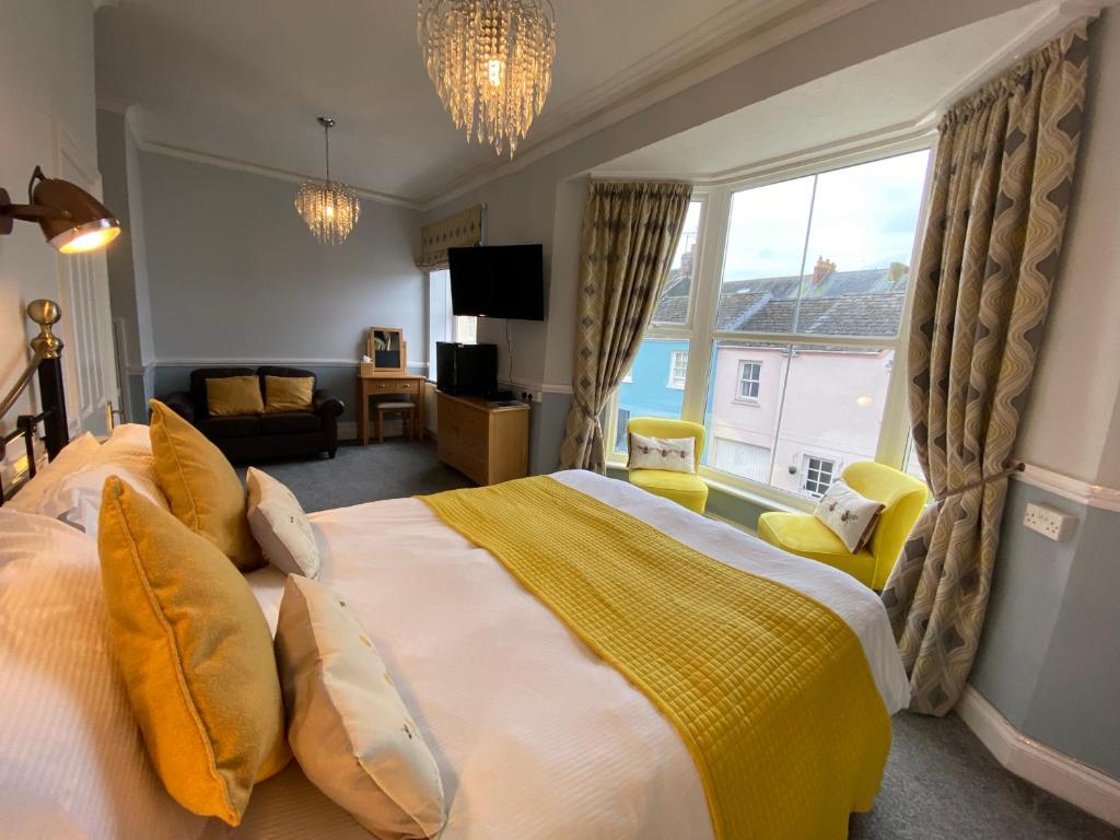 a bedroom with a large bed and a living room at Sunny Bank Guest House in Tenby