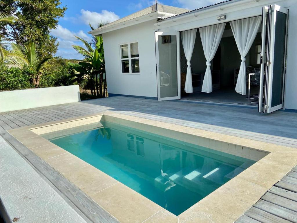a swimming pool in front of a house at Modern 3Bed House in the heart of Swetes village in All Saints