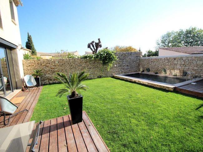 a garden with a potted plant on a wooden deck at La Closerie du Château in Uzès