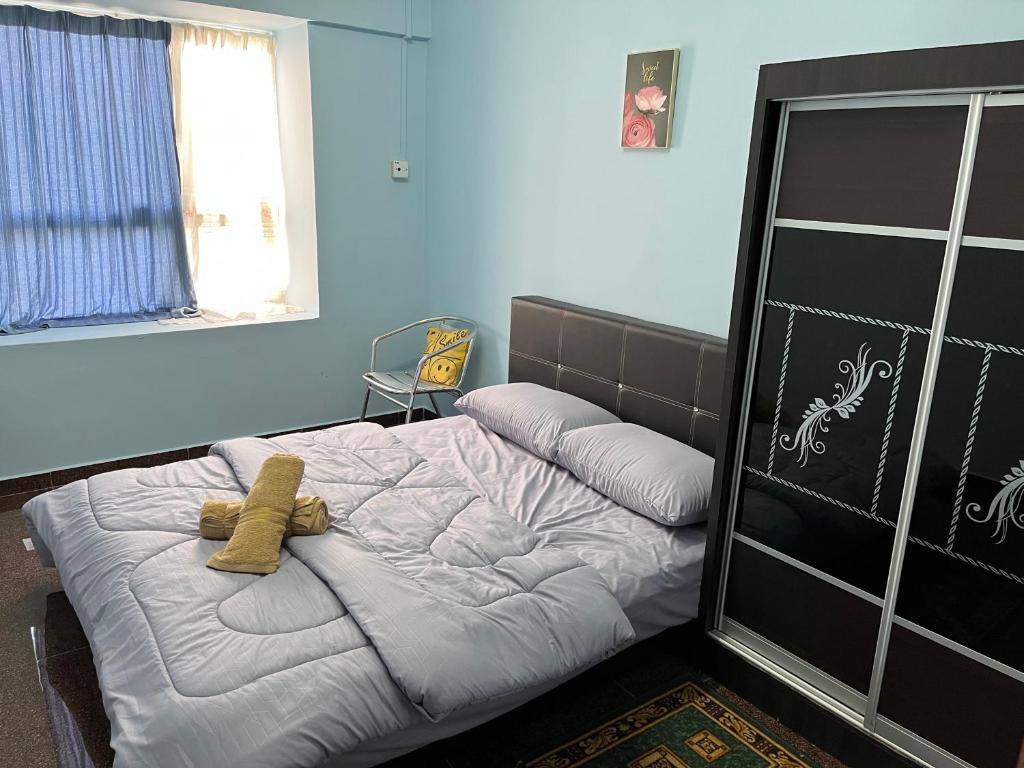 a bedroom with a bed with two teddy bears on it at AF Family Guesthouse in Port Dickson